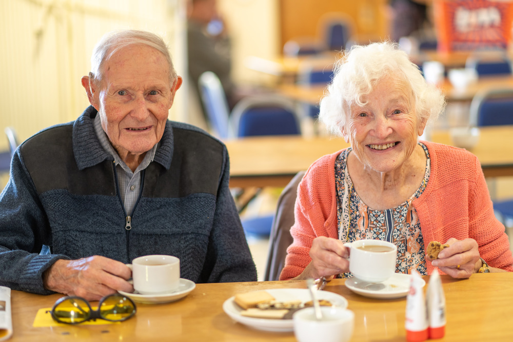 Elderley Couple Sitting Drinking Coffee Smiling