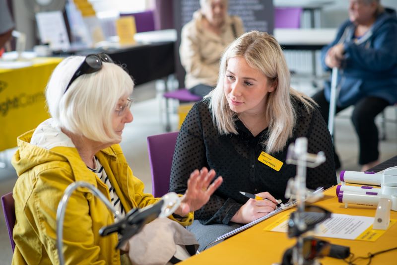 Two women sitting at a table having a discussion.