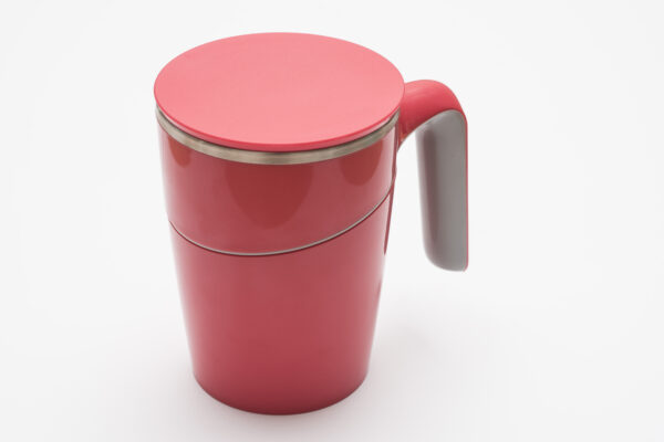 A tall cup with a handle with a lid