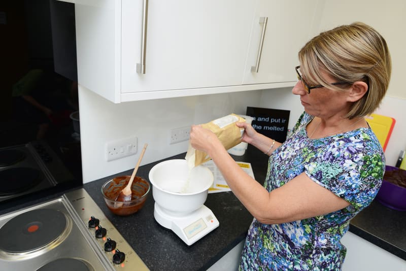 Lady Pouring Flour Into Bowl On Scales