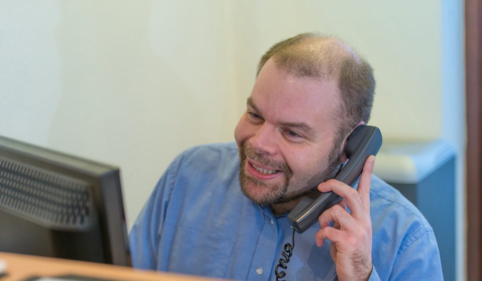 Man In Blue Shirt Answering The Telephone