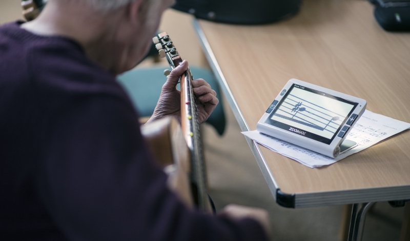 Man Playing Guitar Using Video Magnifier