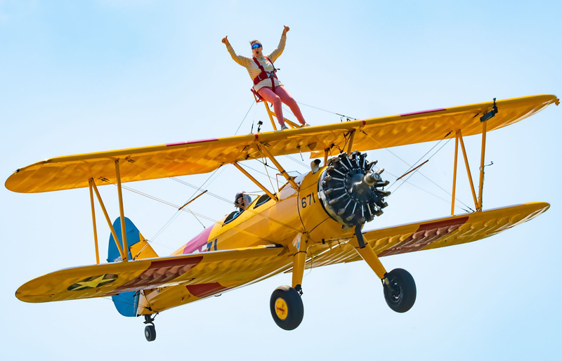 Man Wingwalking On Yellow Plane Putting His Thumbs Up