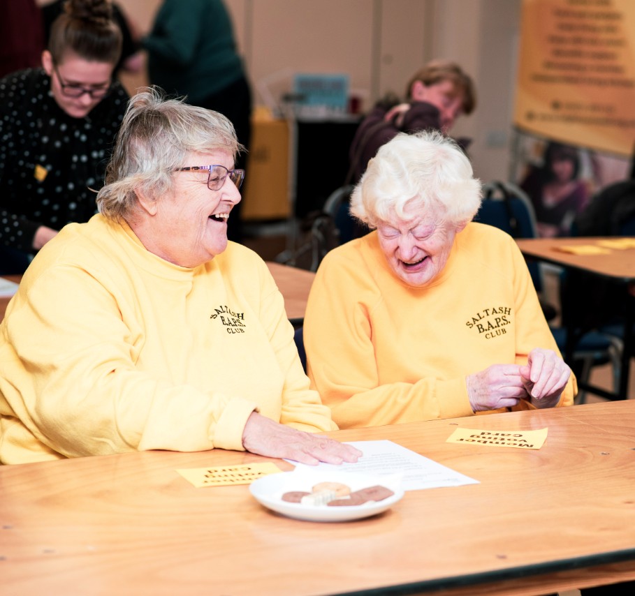 Two Ladies Laughing Sharing Biscuits